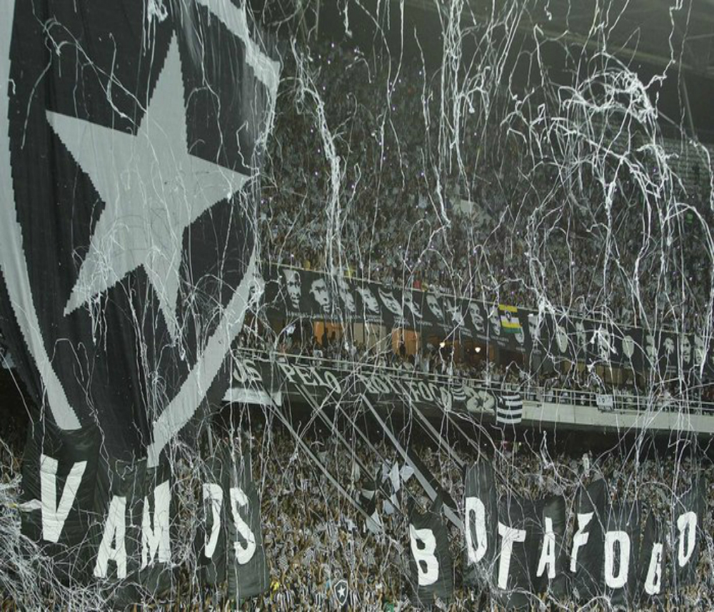 A partida começou para o Botafogo antes de a bola rolar. Com uma festa incrível, a torcida mostrou que manda no Estádio Nilton Santos e contagiou o time. Teve "Vamos Botafogo", escudo gigante de um lado, cachorro enorme do outro, fogos de artifício e chuva de serpentina, além da empolgação de cerca de 40 mil botafoguenses. (Reprodução/Google Imagens)