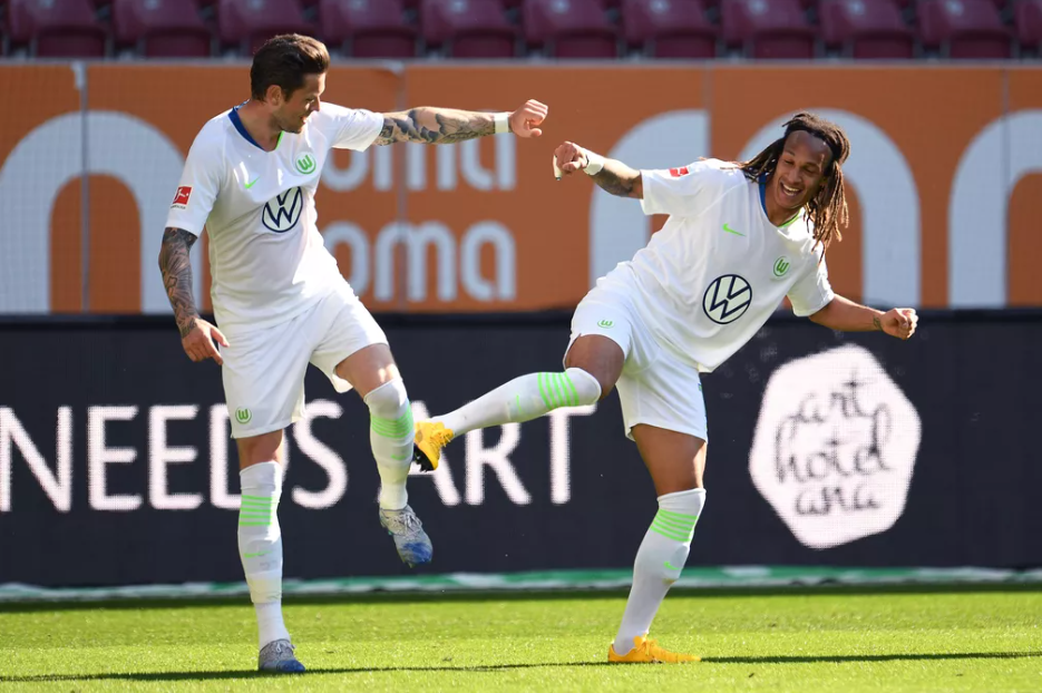 Ginczek, a esquerda, e Mbabu, a direita, comemoram o gol do Wolfsburg seguindo o protocolo. Foto: Tobias Hase.